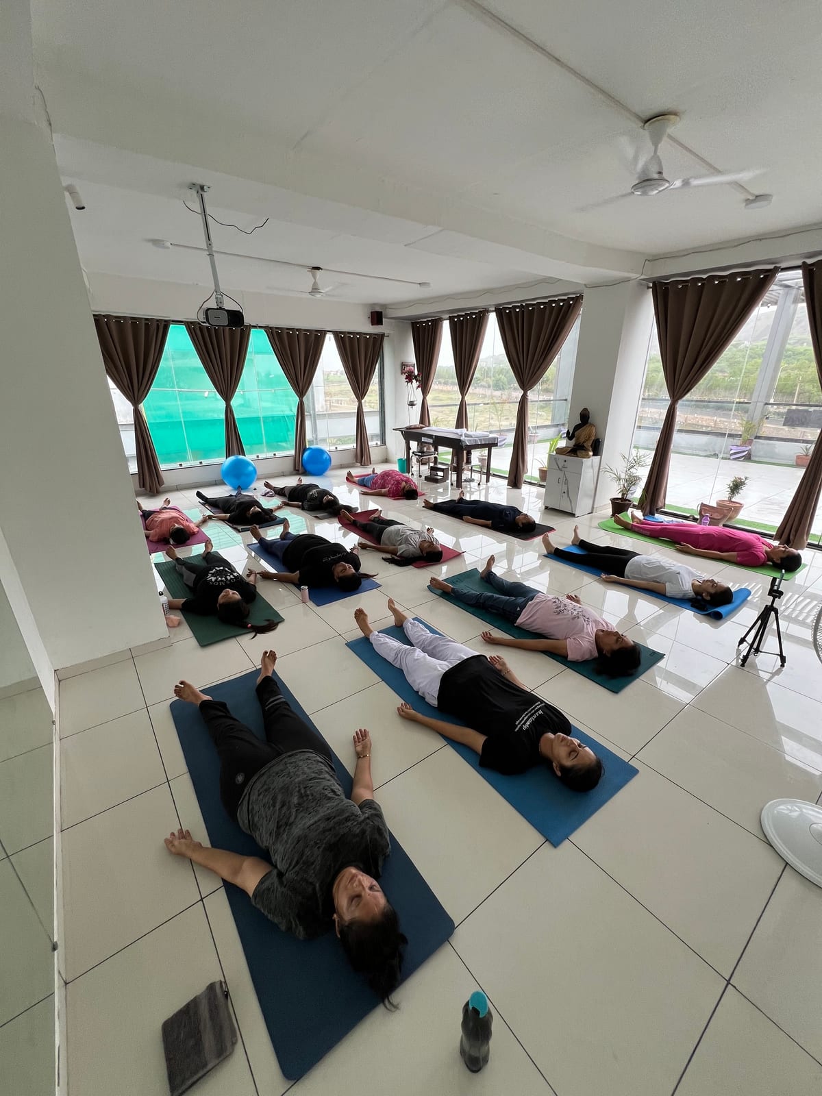 Group class in savasana (final relaxation), students on mats in the studio