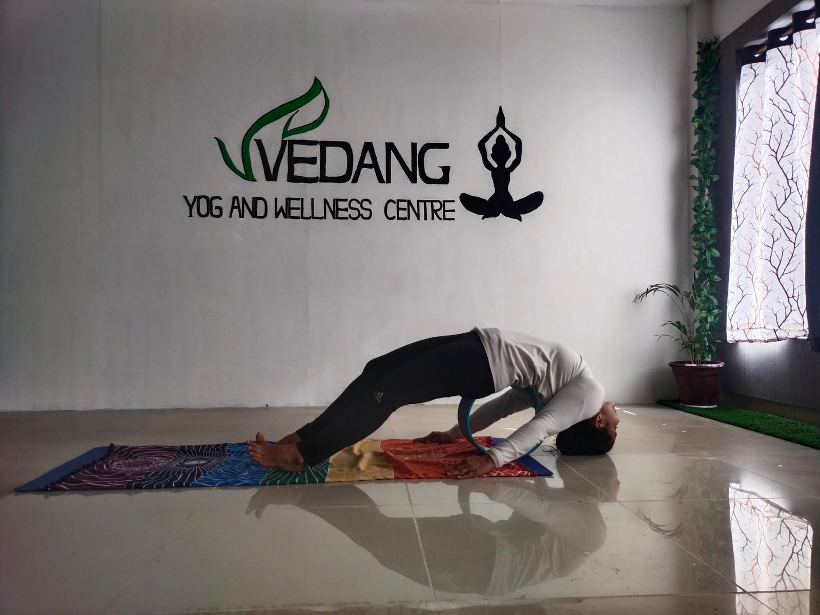 Instructor demonstrating Setu Bandhasana (bridge pose) at the studio