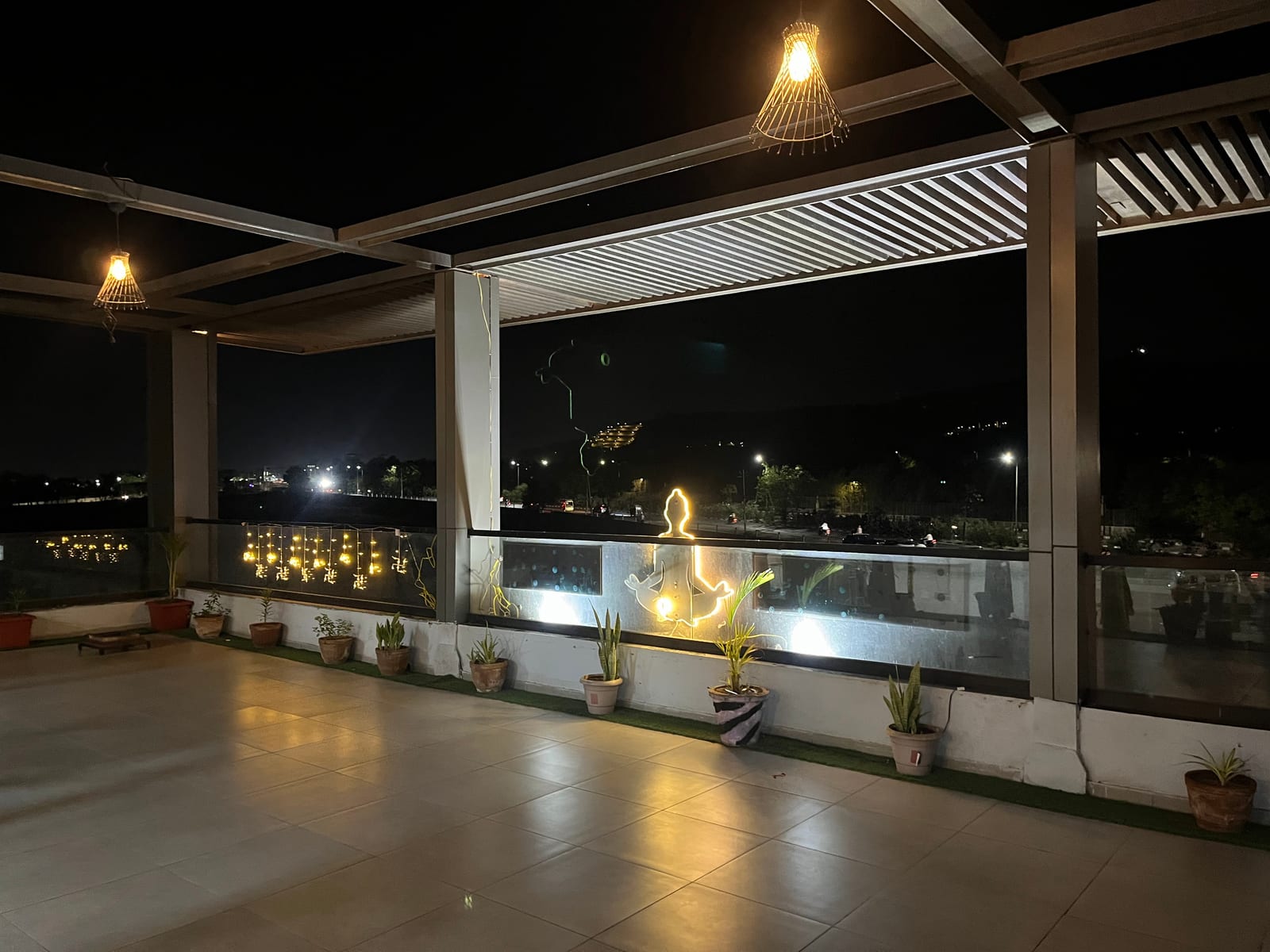 Rooftop terrace at night with fairy lights and illuminated yoga silhouette